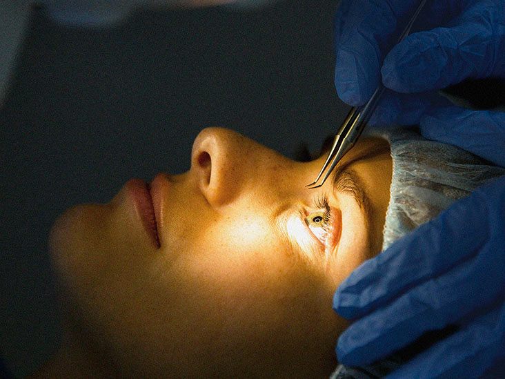 Person holding a brochure titled "Lasik Surgery" with glasses on.