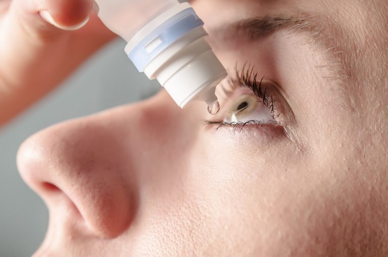 Person rubbing their eye with soap suds visible nearby